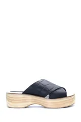 Zueco con plataforma de madera y capellada de cuero negro con textura croco.
