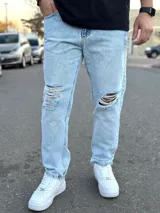 Pantalón mom fit de denim en color celeste claro, con roturas en las rodillas y diseño amplio.
