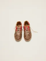 Zapatillas urbanas de cuero con diseño combinado en tonos marrones con estampa de piel de serpiente y detalles en rojo, cordones beige y suela de goma.