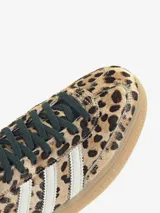 Championes Adidas modelo Handball Spezial con estampado animal print de leopardo. Presentan las icónicas tres tiras laterales en color blanco, cordones negros y una suela de goma color caramelo.