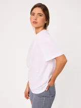 Remera lisa de manga corta, color blanco, con cuello redondo y calce holgado.