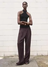 Top sin mangas de cuello halter cruzado, con diseño entallado y cierre posterior.