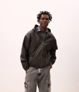Chaqueta masculina de poliuretano color negro, con diseño de capucha, cierre frontal completo y puños elásticos. Presenta un acabado liso y estructura robusta.