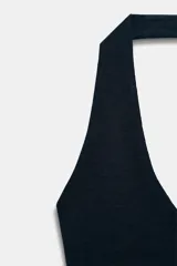 Top de punto con cuello halter y escote redondo, sin mangas y diseño ajustado.