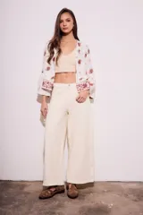 Blusa blanca con bordado de cachemir en negro, corte oversize y mangas acampanadas.