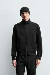 Sudadera de algodón color negro, de corte regular fit, con cuello alto, cierre frontal de cremallera bidireccional y bolsillos frontales de vivo.