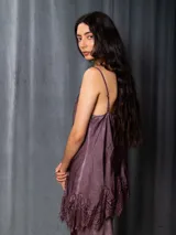 Top de raso asimétrico color morado, con detalles de puntilla en el escote y el bajo. Tiene breteles regulables y elástico en la espalda.