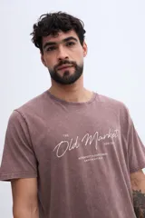 Remera de algodón con efecto lavado de estilo vintage, color marrón, con diseño de estampado tipográfico en el pecho.