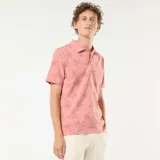 Remera polo rosada de piqué con estampado de palmeras.