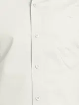 Camisa de manga larga color azul marino, confeccionada en algodón, con cuello abotonado (button-down) y un pequeño logo bordado en el pecho.