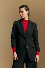 Blazer de corte sastrero con solapas clásicas y estructura definida. Presenta un diseño versátil con silueta ligeramente oversized, ideal para un estilo sofisticado y atemporal.