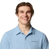 Remera polo de manga corta Columbia, color celeste, con cuello clásico y cierre frontal de botones. Presenta un diseño de tejido técnico con tecnología Omni-Wick para mayor transpirabilidad y elasticidad.