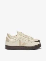 Zapatillas de cuero color blanco con detalles en beige claro, suela de goma marrón oscuro y cordones blancos.