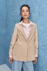 Blazer de corte sastrero con silueta relajada, solapas tradicionales, cierre frontal de un botón y bolsillos de vivo.