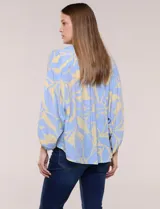 Blusa de gasa texturizada color celeste con estampado abstracto en tono amarillo, de silueta holgada y fluido diseño. Presenta escote en V con cuello a la base y abotonadura frontal con botones a tono. Cuenta con mangas largas abullonadas con puños elastizados.