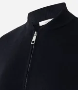 Campera de punto de corte regular y estilo oversized, confeccionada en una mezcla de viscosa, poliéster y poliamida. Presenta cierre frontal completo, mangas largas con puños acanalados y acabado acanalado en el ruedo.