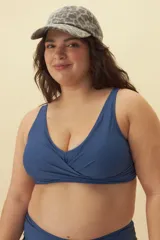 Top de bikini azul con escote en V y detalle cruzado en el centro.