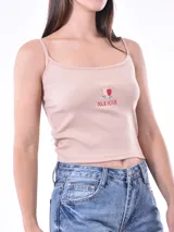 Musculosa blanca con tirantes finos en verde y estampado de palmeras en el pecho.