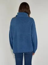 Sweater azul de tejido de punto con cuello alto y apliques de lentejuelas en el frente.