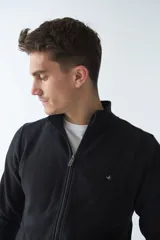 Campera negra de algodón con cierre completo, cuello alto, bolsillos laterales, puños y logo bordado en el pecho.