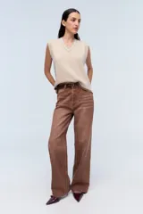 Chaleco de punto color beige con escote en V y ribete blanco.