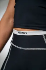 Calza deportiva larga negra con tiro alto y detalles de líneas blancas en los laterales.