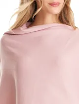 Poncho tejido de punto con diseño asimétrico y aberturas laterales para los brazos.