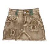 Minifalda marrón de jean con efecto desgastado, apliques metálicos, bolsillos con cierre y ruedo desflecado.