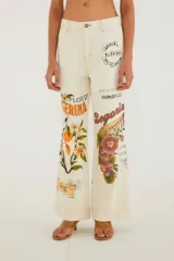 Pantalón de tiro alto y pierna ancha, confeccionado en denim color crudo con costuras a la vista en tono óxido. Presenta un diseño estampado de sellos vintage, flores y postales.