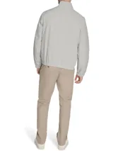 Campera tipo bomber de Tommy Hilfiger en color gris claro. Presenta cierre frontal completo, cuello mao con detalles internos distintivos de la marca, puños y ruedo elásticos, y el logo de la bandera bordado en el pecho.
