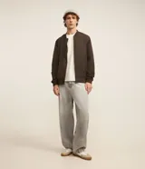 Campera bomber negra para hombre, confeccionada en poliéster con cierre frontal de cremallera, cuello, puños y dobladillo elásticos acanalados, y bolsillos laterales.