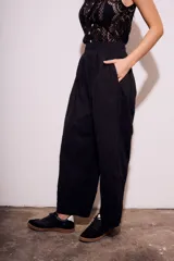Pantalón negro de corte amplio, con cintura elástica y textura arrugada.