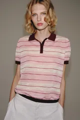 Polo de punto de manga corta con diseño a rayas horizontales en tonos celestes, blancos y finas líneas marrones. Cuenta con cuello clásico y cierre frontal parcial con botones.