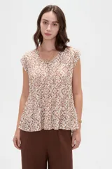 Blusa de poliéster sin mangas con cuello redondo y estampado geométrico en tonos marrones y blancos, de corte holgado y diseño fluido.