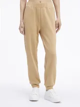 Pantalón de jogging color beige, de corte relajado y tiro medio, con puños ajustados en los tobillos.