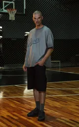 Remera de manga corta, cuello redondo y calce oversize, color gris oscuro con efecto batik/lavado. Estampado frontal con la palabra "Ravers" en tipografía cursiva estilo universitario en tono azul oscuro.