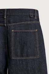 Pantalón jean azul marino oscuro de corte recto y holgado, largo cropped, tiro medio y tejido rígido de denim sin lavado. Cuenta con diseño de cinco bolsillos y costuras en tono tabaco contrastante.