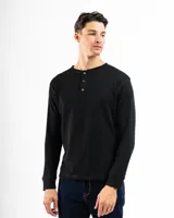 Remera tipo henley de manga larga confeccionada en tejido de algodón con textura mini piqué. Presenta un cierre frontal con tres botones y puños ajustados en las mangas.