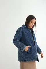 Chaqueta de denim azul con diseño acolchado en forma de rombos, cierre frontal con cremallera y bolsillos laterales.