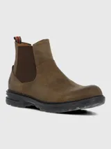 Bota estilo Chelsea color marrón, confeccionada en cuero con paneles elásticos laterales en tono marrón oscuro. Presenta una suela de goma robusta y flexible con tecnología de absorción de impactos y una tira decorativa en la parte trasera con diseño de bandera.