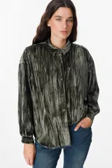 Camisa de manga larga confeccionada en terciopelo con acabado arrugado. Presenta cuello clásico, cierre frontal con botones y puños abotonados.