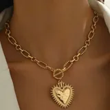 Collar dorado con cadena de eslabones gruesos y dije de corazón con textura martillada.