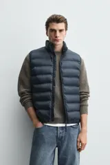 Chaleco acolchado de hombre color negro, con diseño puffer, cuello alto y cierre frontal con cremallera.