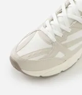 Championes deportivos de estilo urbano con capellada de material sintético, diseño con recortes y apliques superpuestos. Cuenta con cierre de cordones, entresuela robusta y suela de goma con base tractorada.