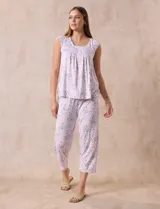 Conjunto de pijama marca René Rofé, compuesto por remera de mangas cortas con escote en V abotonado y pantalón capri con cintura elastizada. Diseño estampado con flores azules sobre fondo blanco.