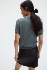 Pollera mini negra entallada de corte evasé, con cierre oculto y corchete en un lateral.