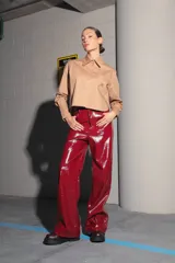 Pantalón de charol rojo de tiro medio alto, con botón metálico níquel, badana de RENÉE en cintura y bolsillos traseros.