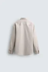 Camisa de hombre color beige claro, de corte slim fit, con cuello italiano, manga larga y cierre frontal de botonadura.