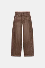 Jeans de tiro medio con diseño wide leg, confeccionados en denim color marrón con efecto lavado. Presentan cinco bolsillos, cierre frontal con cremallera y doble botón metálico.