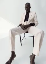 Pantalón de vestir de lino color beige, de corte recto y tiro medio, con trabillas, bolsillos laterales y bolsillos posteriores de ribete.